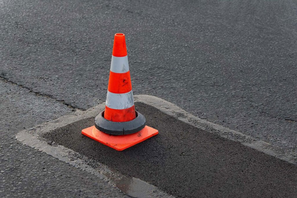 pothole repair with safety cone on top